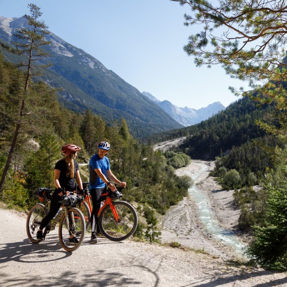 Zwei Fahrradfahrer sind mit dem Gravelbike auf dem Schotter unterwegs
